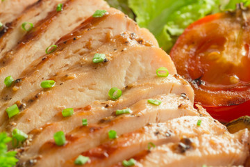 Homemade chicken breast fillet barbecue with grilled vegetables. Close-up concept of chicken breast barbecue.Sliced grilled chicken breast served with vegetable and sprinkle with chopped spring onion.
