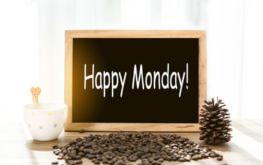 Happy Monday message on blackboard with coffee mug and coffee beans decoration