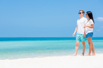 Tourist couple at beautiful white sand beach in summer
