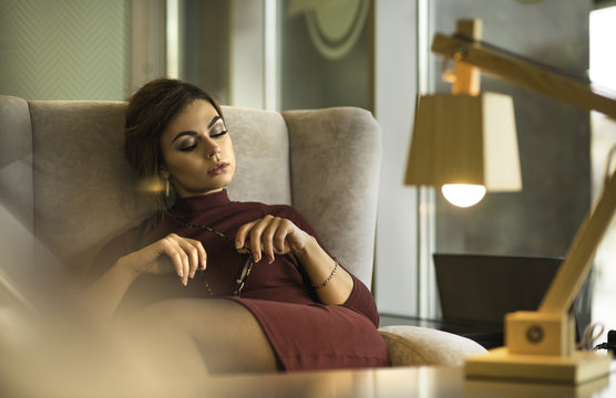 Beautiful Sexy Woman In Restaurant Cafe. Lady Resting At Retro Villa Hotel With Hairstyle Makeup In Evening Dress. Pretty Young Woman In Cafe.