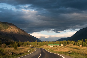 Naklejka premium Asphalt winding road in the mountainous area in the summer and sky with clouds