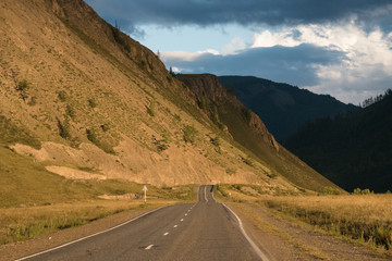 Asphalt winding road in the mountainous area in the summer and sky with clouds