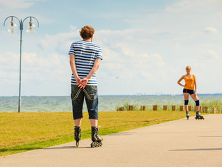 Young couple on roller skates riding outdoors