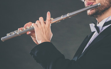 Elegantly dressed male musician playing flute © anetlanda
