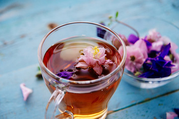 cup of tea with chamomile flowers on rustic wooden background