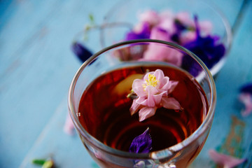 cup of tea with chamomile flowers on rustic wooden background