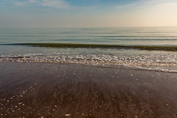 Obraz premium Blick auf Meer vom Strand aus, blauer Himmel und Wellen