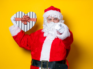 Funny Santa Claus holding heart shape gift