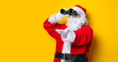 Funny Santa Claus holding binoculars