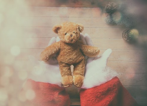 Naklejka Santa Claus holding teddy bear toy
