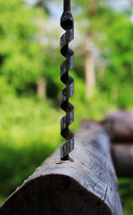 Metal spiral drill for making holes in logs when assembling a wooden frame and building a house