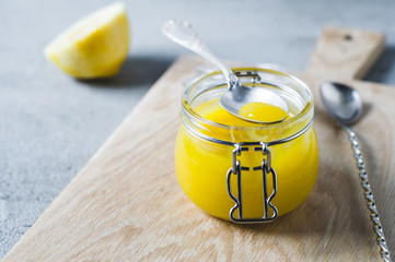 Lemon curd and ingredients on a gray concrete background