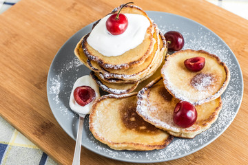Sweet pancakes with berries and fruits on a wooden background