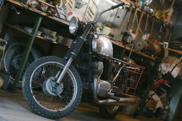 Old vintage motorcycle, which needs to be repaired, in the workshop
