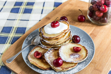 Sweet pancakes with berries and fruits on a wooden background