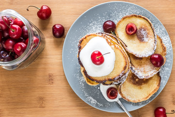 Sweet pancakes with berries and fruits on a wooden background