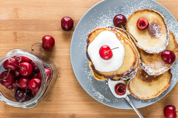 Sweet pancakes with berries and fruits on a wooden background