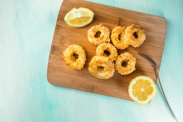 Calamari rings with lemon and copy space, overhead shot