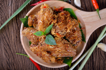 fried chicken wing with herbs in wooden plate and on wooden table