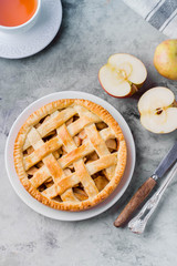 Popular American apple pie and cup of tea on gray table. Homemade classical friut tart. Copy space