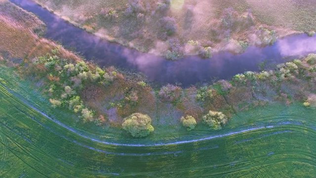 4K Aerial. Morning nature landscape with  small stream and fog. Top view