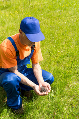 ?arpenter in blue working equipment  holds a pile of screws in his hands