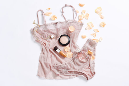 Shopping and fashion concept. Set of glamorous stylish sexy lace lingerie with cosmetic products, perfume, flower petals. Woman accessories on white background. Top view point, flat lay.