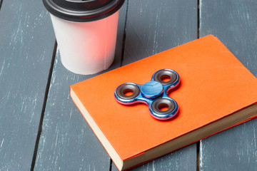 Workplace with coffee cup, spinner and book
