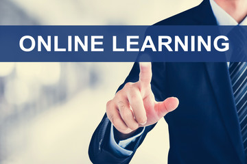 Businessman hand touching ONLINE LEARNING tab on virtual screen