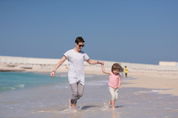 mother and daughter running on the beach