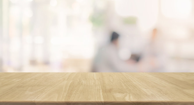 Wood table top and blurred restaurant kitchen interior background - can used for display or montage your products.