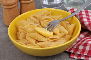 Assiette de penne avec un morceau de beurre