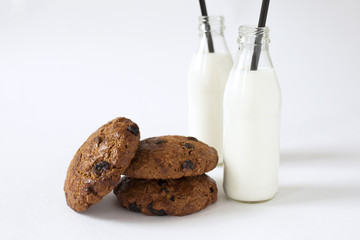 Breakfast of some cookies with raisins and two bottles of milk