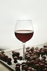 Cherries and a glass with a cherry drink