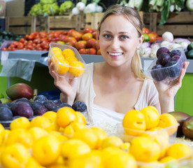 Woman looking plums in fruit store
