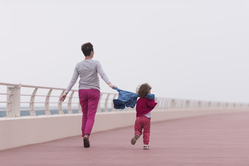 mother and cute little girl on the promenade by the sea