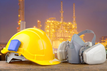 Hard hat helmet and gas respirator with industrial backdrop