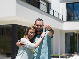 couple hugging in front of  new luxury home