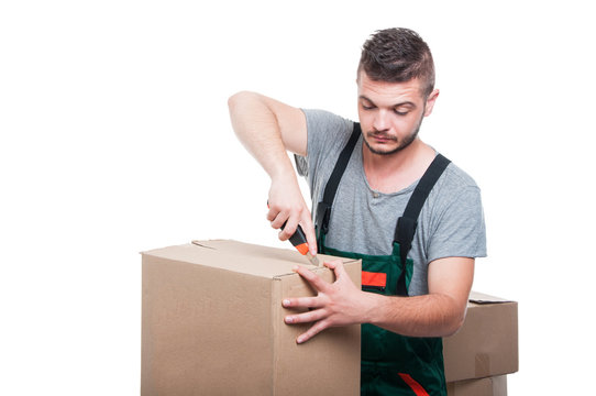 Mover man using cutter tool on cardboard boxes
