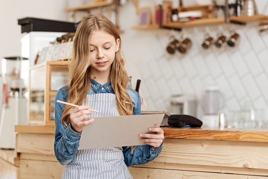 Charming teenage girl thinking about the improvements of menu