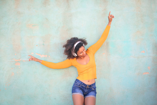 Cheerful girl listening music and dancing