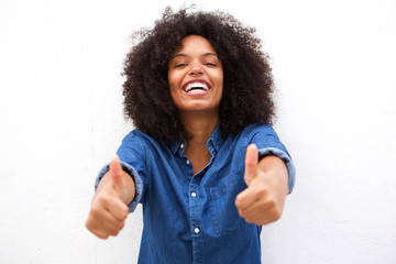 smiling black woman with two thumbs up against white background