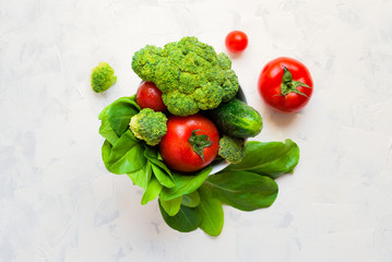 Lettuce leaves, cherry tomatoes, cucumber and broccoli on white background.