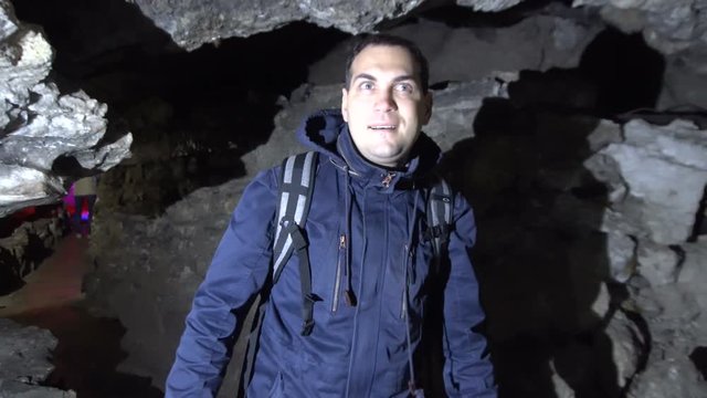 Male Traveler Walking Inside Ice Cave