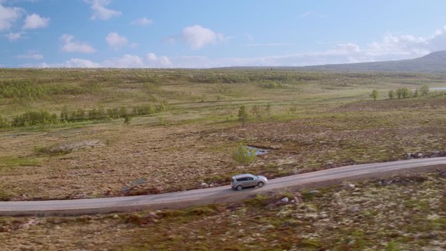 Car driving on rural road over marshlands