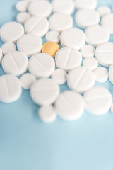 Close up of white tablets with one yellow pill