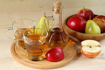 Apple cider and fruit on wooden background.