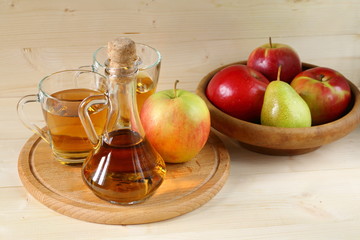 Apple cider and fruit on wooden background.