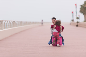 mother and cute little girl on the promenade by the sea