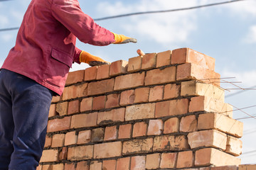 Worker builds a brick wall in the house